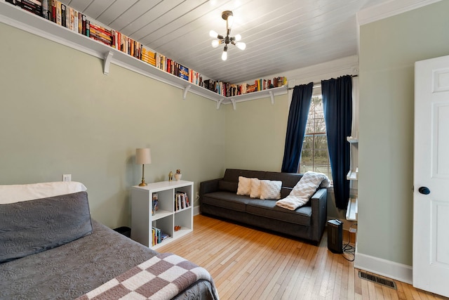 bedroom featuring an inviting chandelier, wood ceiling, and hardwood / wood-style flooring