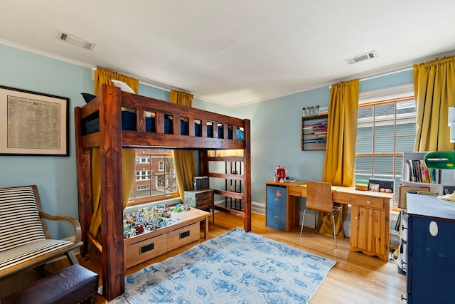 bedroom with crown molding and light wood-type flooring