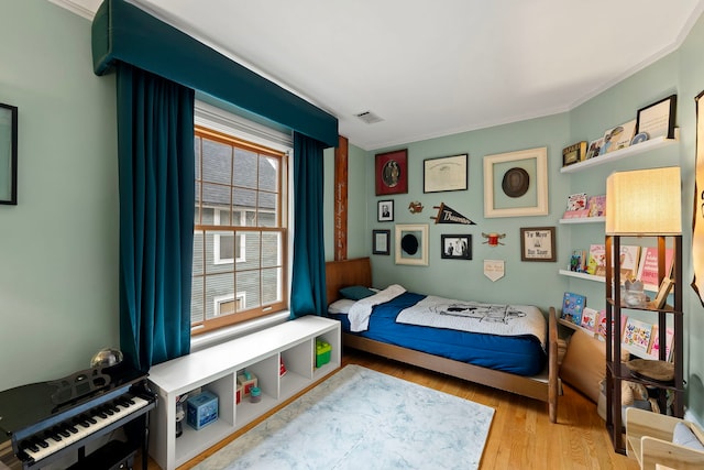 bedroom with crown molding and light hardwood / wood-style flooring