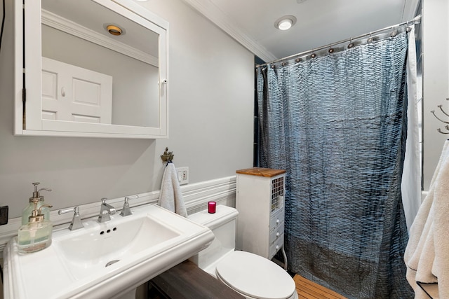 bathroom with a shower with curtain, ornamental molding, toilet, and sink