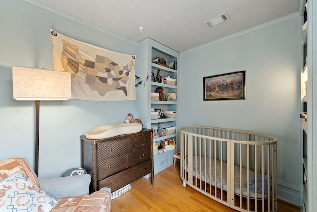 bedroom with crown molding and light wood-type flooring