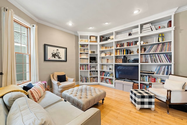 sitting room featuring ornamental molding and light wood-type flooring