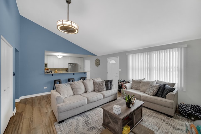 living room featuring light hardwood / wood-style floors and high vaulted ceiling