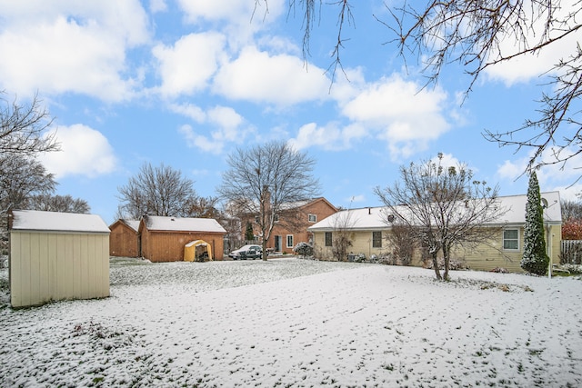 yard covered in snow with a storage unit