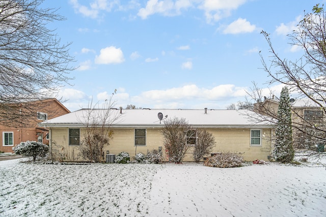 snow covered house with central AC unit