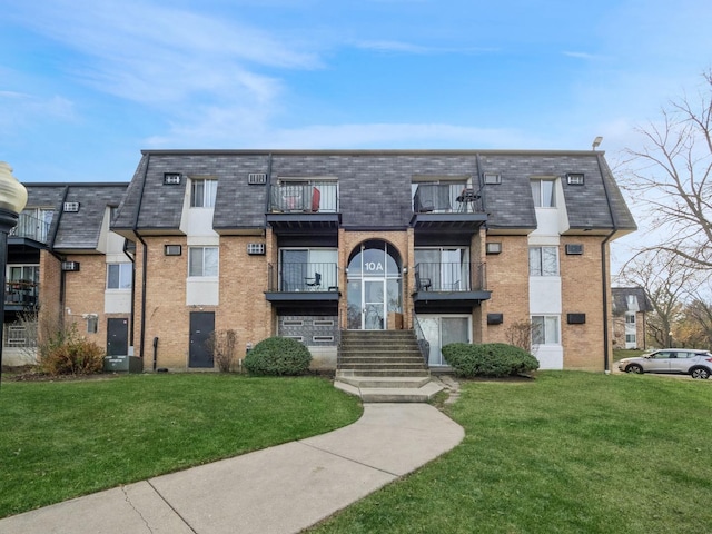 view of front facade with a balcony and a front yard