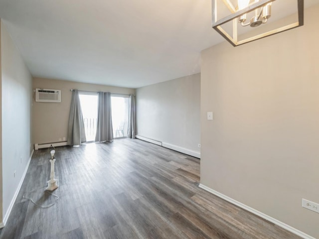 interior space featuring a notable chandelier, dark wood-type flooring, a wall unit AC, and a baseboard heating unit