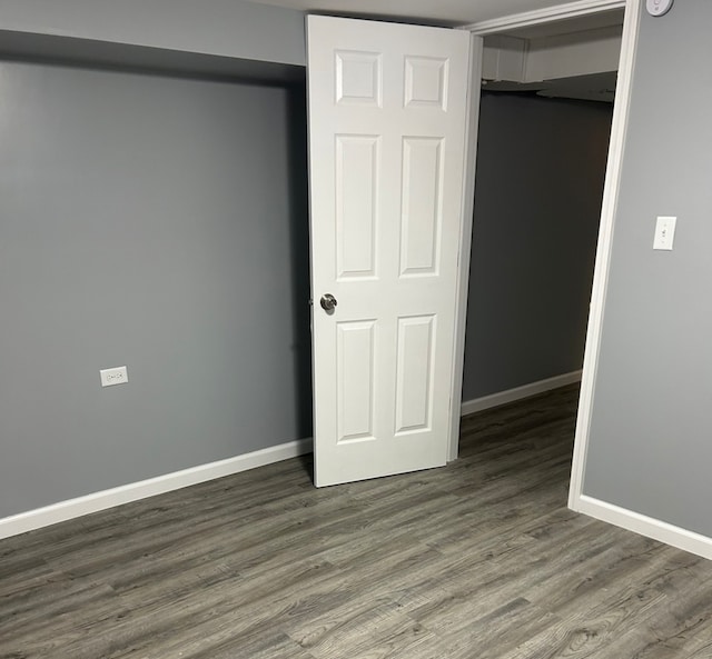 unfurnished bedroom featuring a closet and dark wood-type flooring