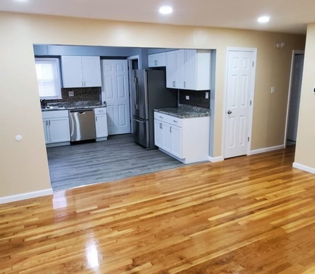 kitchen featuring hardwood / wood-style flooring, white cabinets, and stainless steel appliances