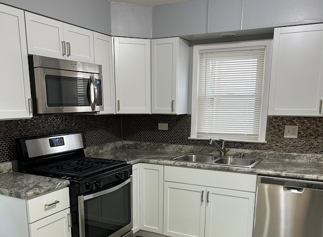 kitchen with tasteful backsplash, white cabinetry, sink, and stainless steel appliances