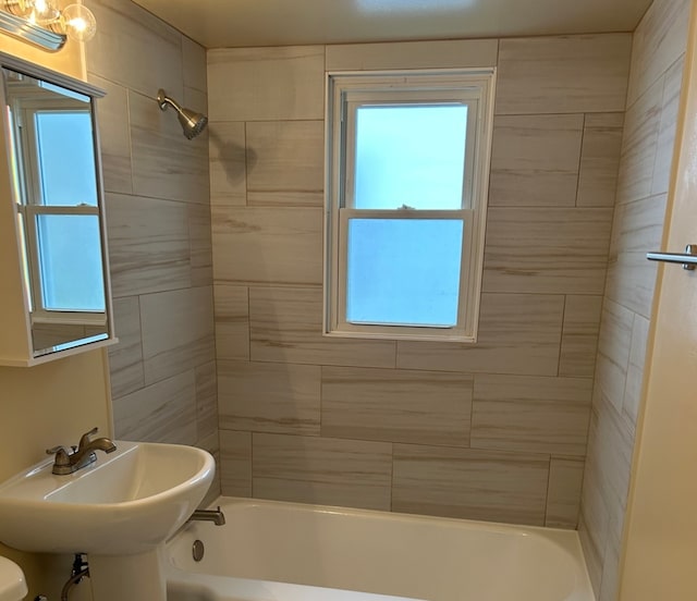 full bathroom featuring toilet, tiled shower / bath, and sink