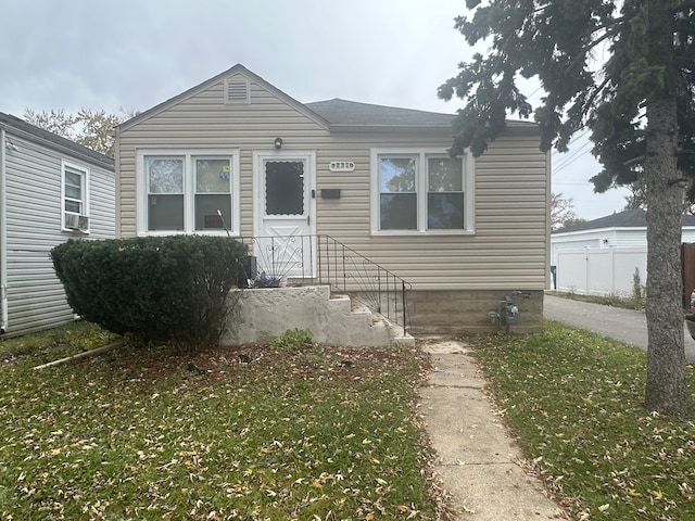 bungalow-style home with a front yard