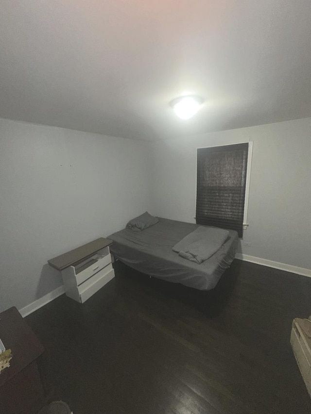 bedroom with dark hardwood / wood-style flooring