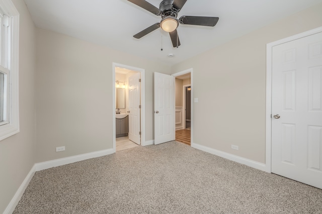 unfurnished bedroom with connected bathroom, ceiling fan, and light colored carpet