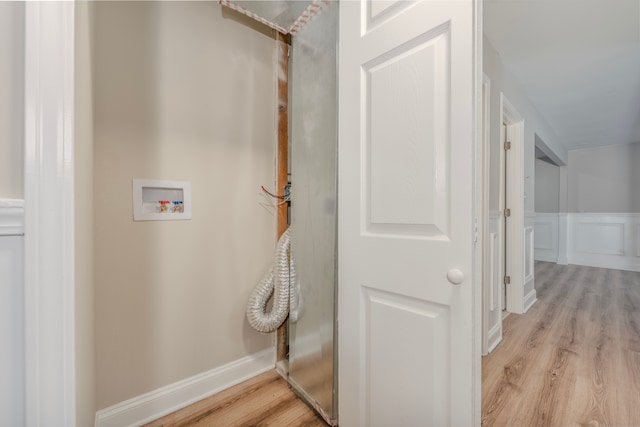 clothes washing area featuring light hardwood / wood-style floors and hookup for a washing machine