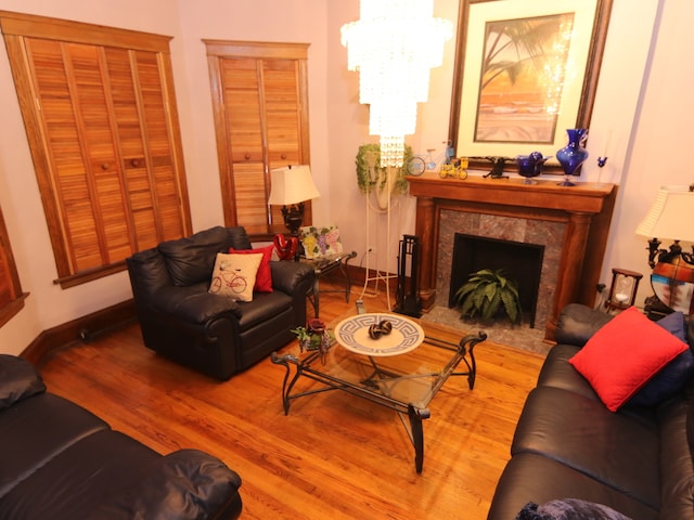 living room with a chandelier, hardwood / wood-style floors, and a high end fireplace