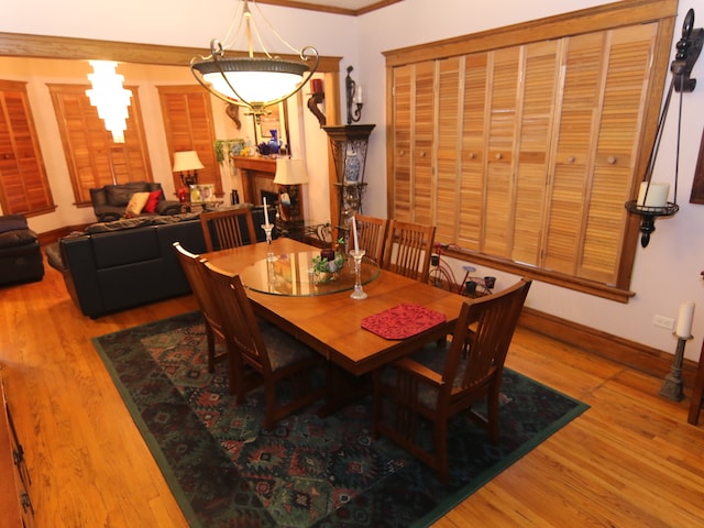 dining room with wood-type flooring and crown molding