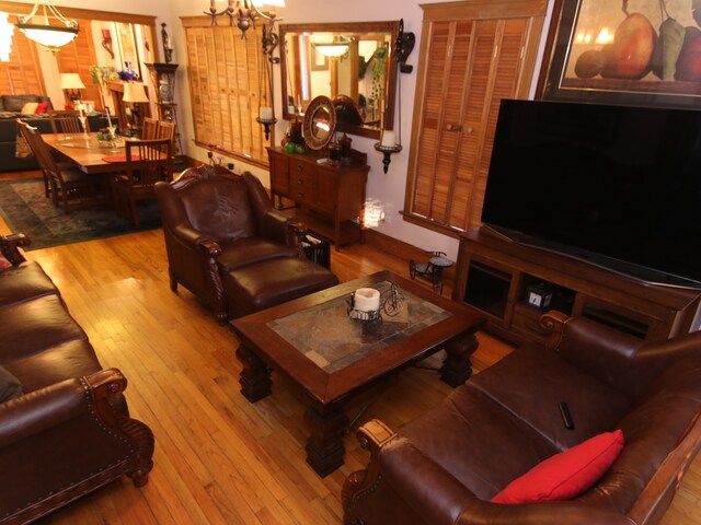 living room with a chandelier and light wood-type flooring