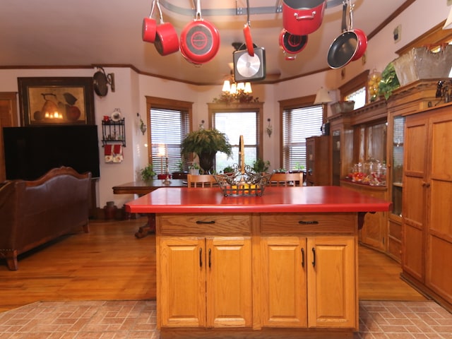 kitchen with plenty of natural light, a center island, light hardwood / wood-style floors, and an inviting chandelier