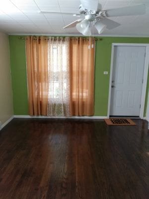 empty room with hardwood / wood-style floors and ceiling fan