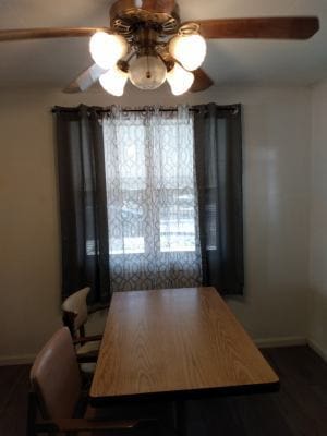 dining area with ceiling fan and dark hardwood / wood-style floors