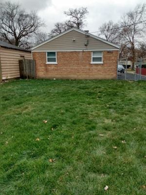 rear view of property with a lawn