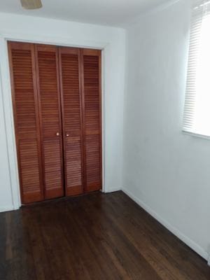 unfurnished bedroom featuring a closet and dark hardwood / wood-style floors