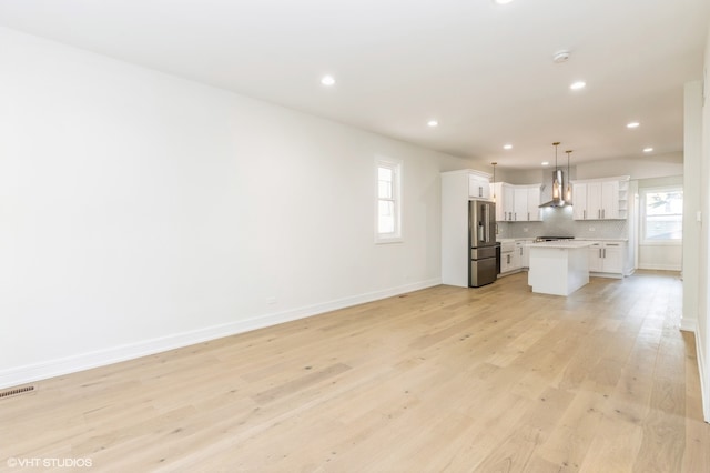 unfurnished living room with a healthy amount of sunlight and light wood-type flooring