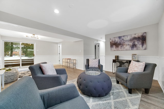 living room with hardwood / wood-style floors and a notable chandelier