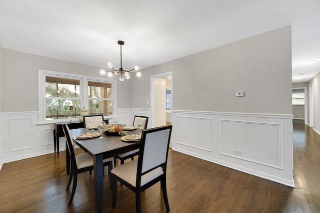 dining area featuring dark hardwood / wood-style floors and an inviting chandelier