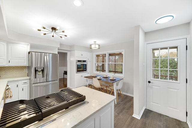 kitchen with white cabinets, dark hardwood / wood-style floors, a healthy amount of sunlight, and appliances with stainless steel finishes