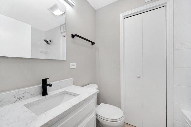 bathroom with vanity, toilet, and a shower