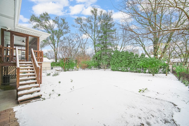 yard covered in snow featuring a sunroom