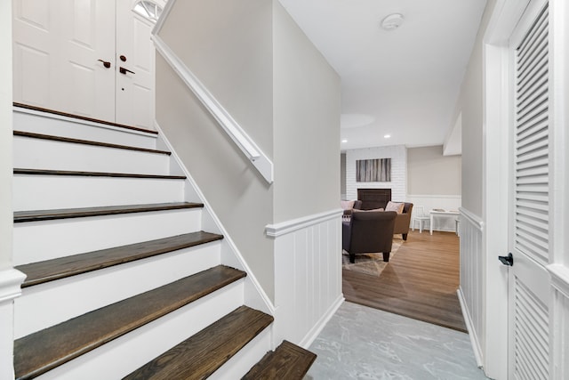 staircase featuring hardwood / wood-style floors and a fireplace