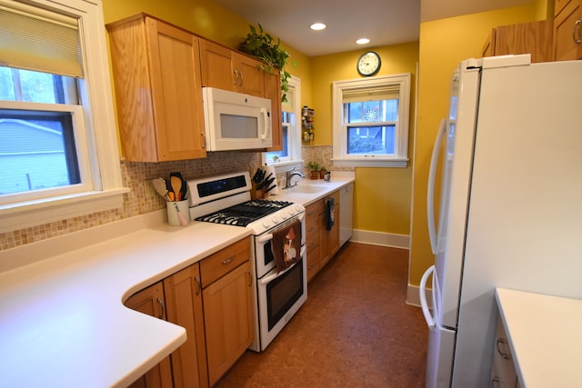 kitchen with white appliances, tasteful backsplash, plenty of natural light, and sink