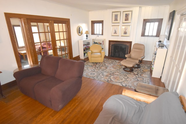 living room with a fireplace, plenty of natural light, hardwood / wood-style floors, and french doors