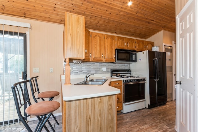 kitchen featuring wood walls, sink, dark wood-type flooring, and black appliances