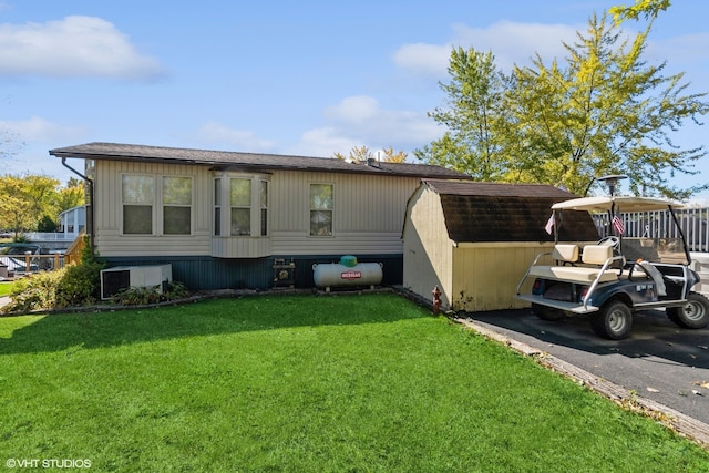 view of front of house featuring a front lawn and a shed