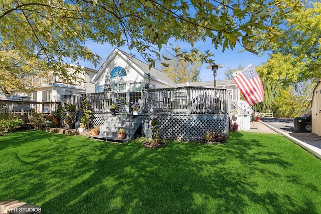 rear view of property featuring a yard and a deck