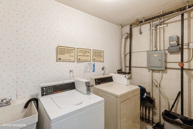 clothes washing area featuring washing machine and dryer, sink, and electric panel