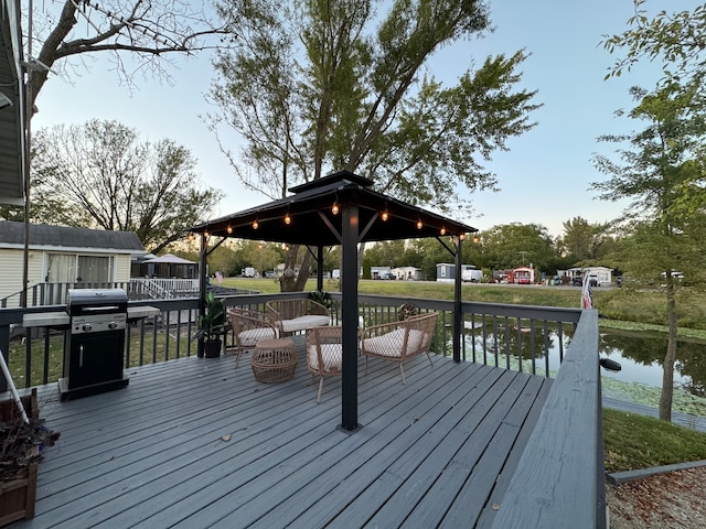 wooden terrace featuring a gazebo, a water view, and a grill