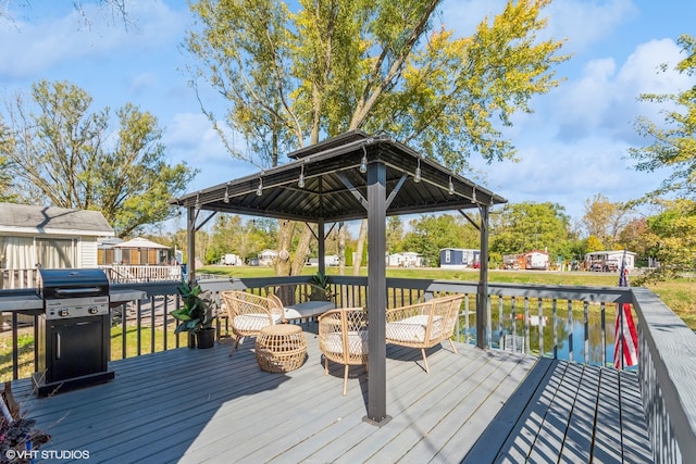 deck with a gazebo, a water view, and area for grilling