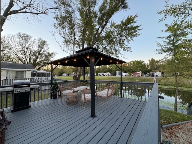 wooden terrace with a gazebo, a water view, and area for grilling