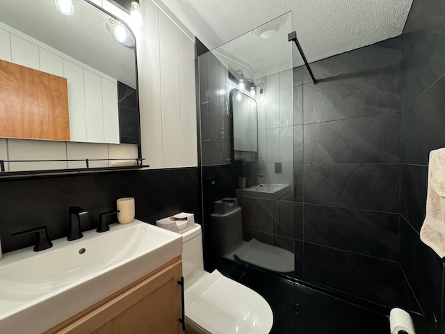 bathroom featuring backsplash, vanity, a textured ceiling, and tile walls