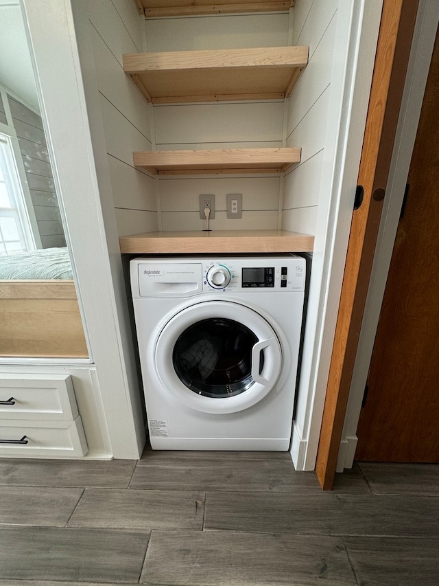 laundry room with dark wood-type flooring and washer / dryer