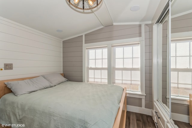 bedroom with wooden walls, dark hardwood / wood-style floors, and lofted ceiling