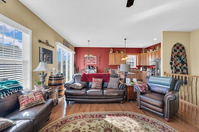 living area with light wood-style flooring and a notable chandelier