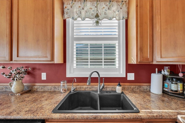 kitchen with dishwashing machine, light countertops, and a sink