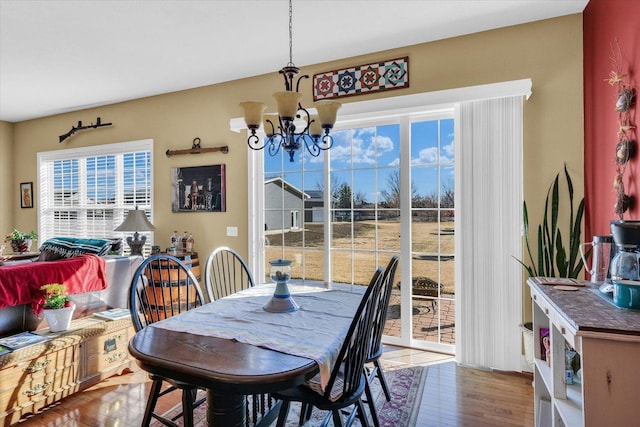 dining space with a chandelier and wood finished floors