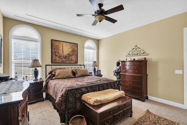 bedroom featuring a ceiling fan, light colored carpet, and baseboards